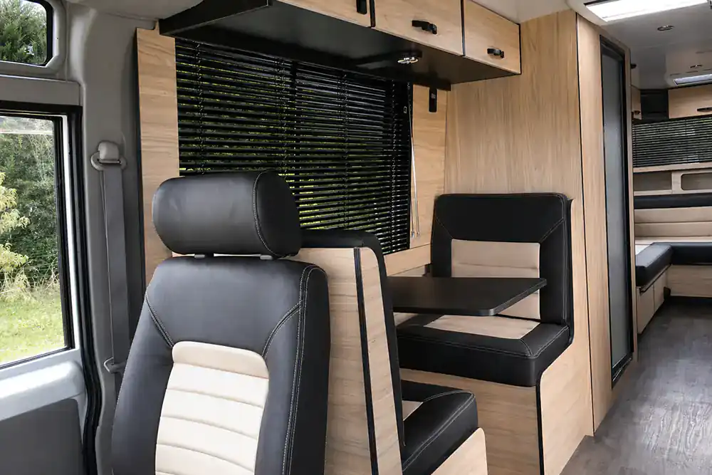 Custom campervan cab connected to a finished lounge and cabinetry