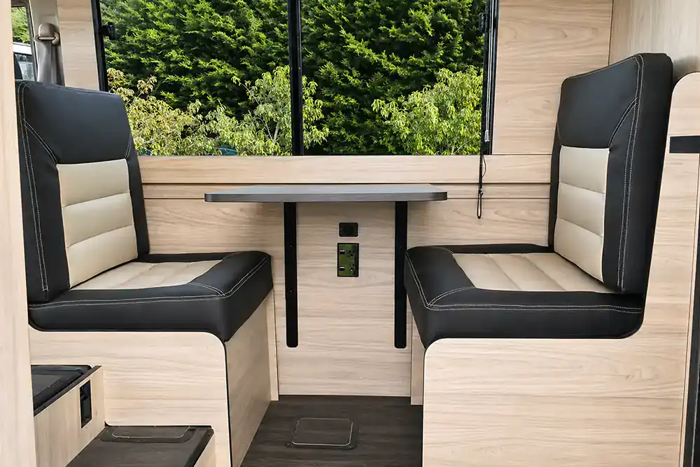 Finished custom campervan dinette with upholstered seating and removable table